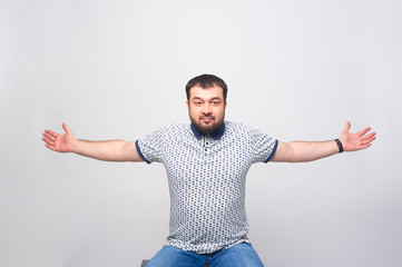 A man warmly greets the viewer with his arms spread wide over a white background. - obrazy, fototapety, plakaty