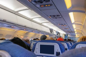 Inside of an airplane cabin with passengers on flight