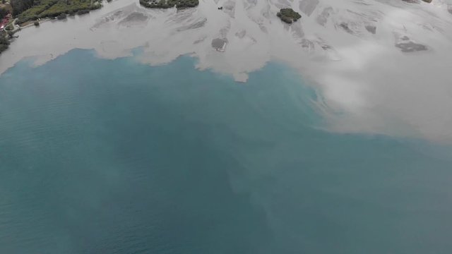 where two colors come together blue mix grey water, tilt up to reveal epic alpine landscape darth valley 4k