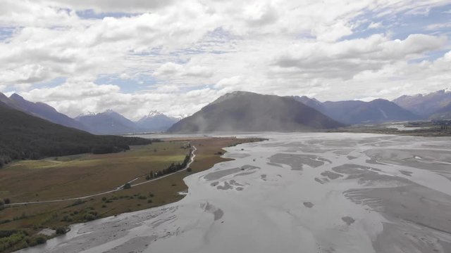 cars drive Darth valley road new zealand sand storm in epic dramatic back ground mountain alpine landscape