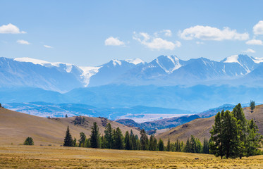 Scenic view, Altai mountain. Snow-capped peaks in blue haze. Travel and vacation in the mountains.