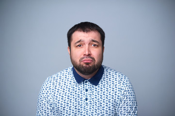Offended portrait of a bearded man on a white background.