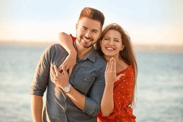 Happy engaged couple near river