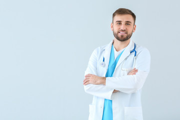 Portrait of male doctor on light background