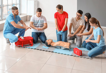 Instructor demonstrating CPR on mannequin at first aid training course