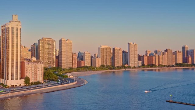 Aerial: speedboat on Lake Michigan & the chicago city skyline at sunrise. USA