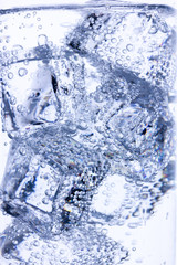 background of ice cubes doused with mineral water with air bubbles