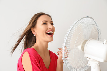 Fototapeta Happy woman with electric fan on white background obraz