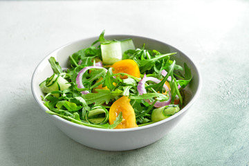Bowl with tasty salad on light background