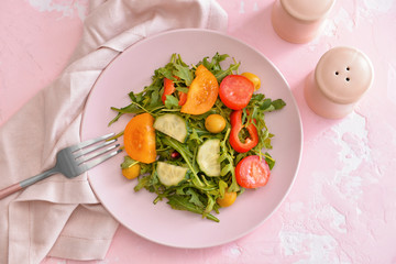 Plate with tasty salad on table