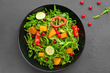 Plate with tasty salad on grey background © Pixel-Shot