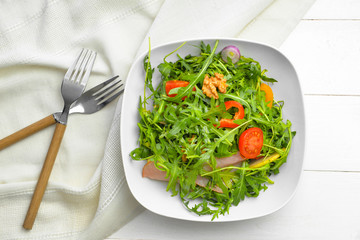 Plate with tasty salad on table