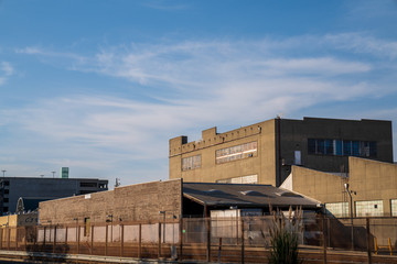 Obraz premium Grey industrial warehouse area behind fenced off railroad tracks