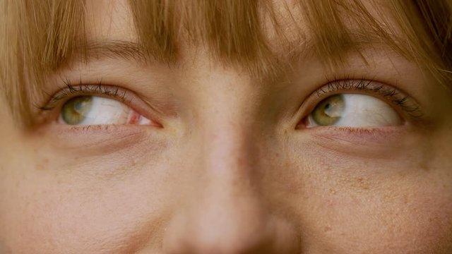 Caucasian pretty woman loooking around with her green eyes in slow motion,potrait