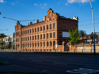 Fototapeta premium Red brick school building sunny summer day shiny perspective view