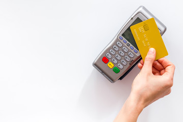 Contactless payment, paypass. Hand hold bank card near terminal on white background top-down copy space