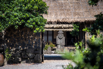 Scenery of Dol Hareubang statue inside Seongeup Folk Village in Jeju island, South Korea.