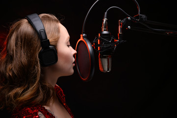 Girl sings in the studio, a spectacular photo of a vocalist musician in the studio with red smoke....