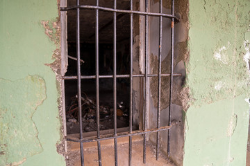 Steel bars blocking entrance of window in rustic dilapidated secured complex
