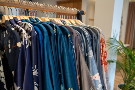 Various designer kimonos garments hanging on rack in store