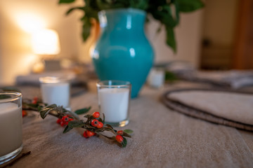 Twig and berries simple table decoration next to vase and candles on dinner setting