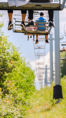 Vertical frame Chairlifts with tourists against trees and sky in park City Utah at off season
