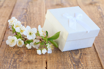 Gift box on wooden boards with flowers of jasmine.