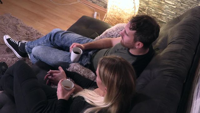 couple in love are hugging with a coffee mug on the couch