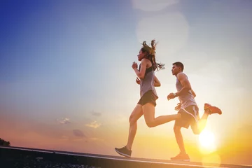  Young couples running sprinting on road. Fit runner fitness runner during outdoor workout with sunset background © Panumas