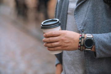 man hand close up holding disposable coffee cup