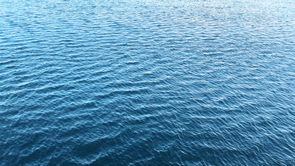 Fototapeta premium Background texture of ocean calm waves with ripples on the surface of the sea water ,warm tone color, Sea background ocean beautiful nature water surface waves horizon surface texture. 