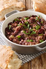 traditional tasty lobio served with Georgian bread close-up in a pan on the table. vertical