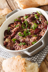 Georgian red bean lobio served with traditional bread close-up in a pan on the table. vertical