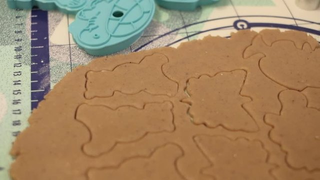 Raw dough with cut out gingerbread cookies and plastic cutters in shapes of animals . Slow motion close up shot on a gimbal. Czech Republic
