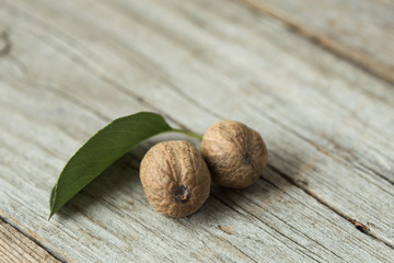 Dried seeds of fragrant nutmeg and grated nutmeg on wooden background.