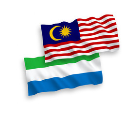 National vector fabric wave flags of Sierra Leone and Malaysia isolated on white background. 1 to 2 proportion.
