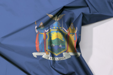 New York fabric flag crepe and crease with white space, coat of arms of the state of New York on blue field.