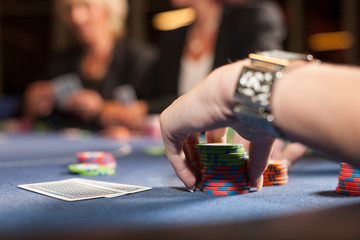 Eine Frauenhand hält viele Jetons beim Pokerspiel