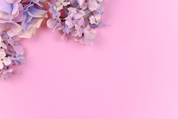 Background with artificial textile hydrangea flowers in upper leftcorner and pink copy space 