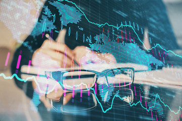 Forex chart hologram on hand taking notes background. Concept of analysis. Multi exposure