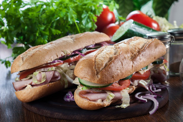 Submarine sandwiches with ham, cheese and vegetables