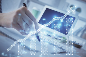 Financial forex graph drawn over hands taking notes background. Concept of research. Multi exposure