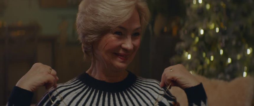 CU elderly retired woman receives a gift with with jewelry from her husband on Christmas Eve. Shot on ARRI Alexa Mini with Cooke 2x Anamorphic lenses. 4K UHD RAW Graded footage