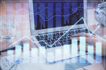 Multi exposure of market chart with man working on computer on background. Concept of financial analysis.