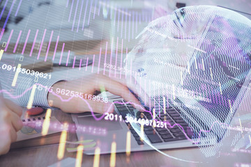 Double exposure of stock market graph with man working on laptop on background. Concept of financial analysis.