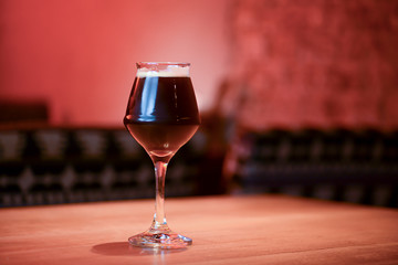 Glass of dark beer on the counter table in bar. Alcohol drink. Food photography concept, copy space.