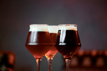 Three glasses with different beer on wooden table in a bar. Food photography concept, with copy space