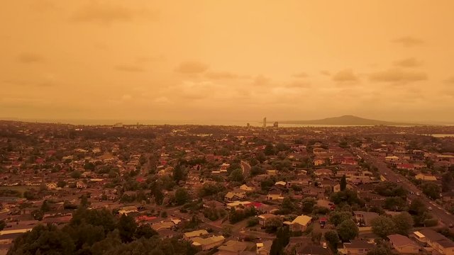 Drone Aerial footage of hazy orange skies in Auckland, New Zealand due to bushfires in Australia.
