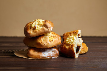 Wheat buns with jam and curd filling on a wooden table, closeup. Bakery, stack of buns with cottage cheese