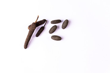long pepper or piper longum and brown ayurvedic pills spread on white background. Ayurvedic medicines concept